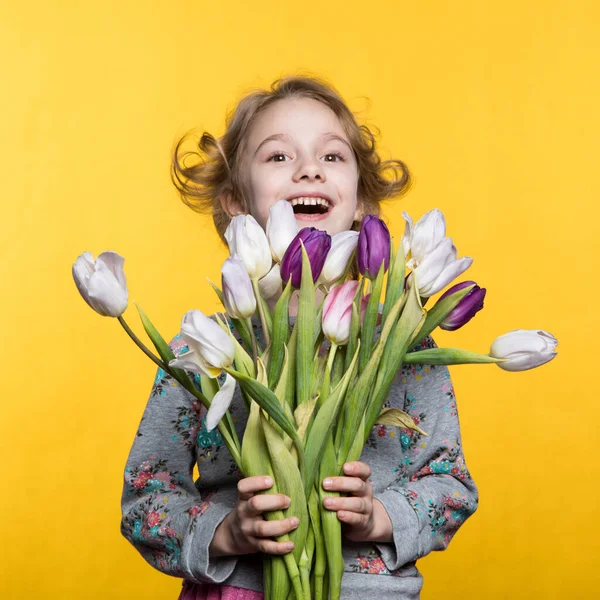 Klein meisje met een boeket tulpen — Stockfoto