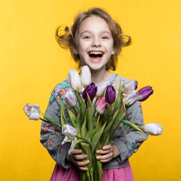 Klein meisje met een boeket tulpen — Stockfoto