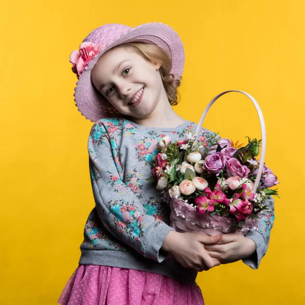 Little smile girl with flowers in basket. — Stok fotoğraf
