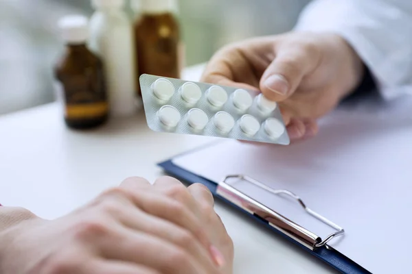 Médico de perto prescreve medicamento a um paciente — Fotografia de Stock