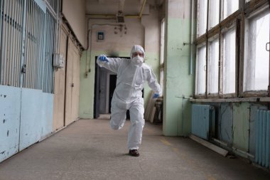 Koruyucu kıyafetli bir adam insanları tahliye ediyor.