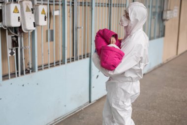 Koruyucu kıyafetli bir adam insanları tahliye ediyor.