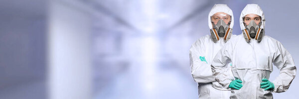 Женщина и мужчина в химической защитной одежде и противогаз маске
 .