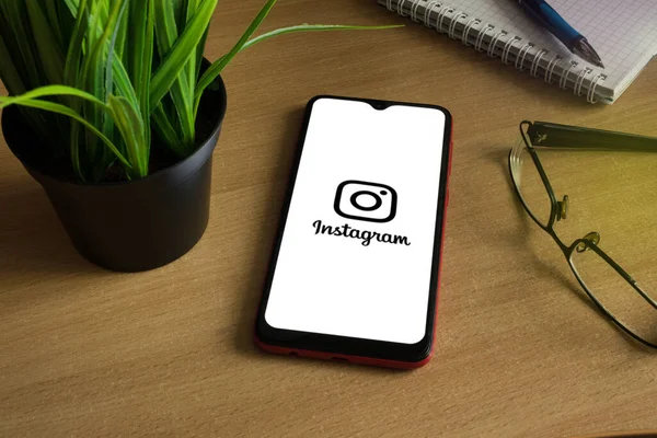 Minsk 12.05.2020. Smartphone på ett träbord med bild på Instagram. — Stockfoto