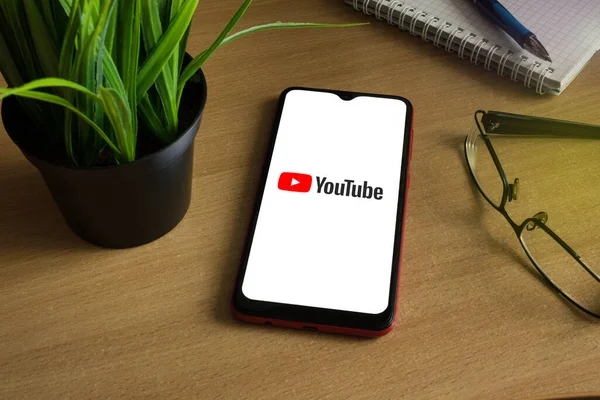 Minsk 12.05.2020. Smartphone auf einem hölzernen Hintergrund mit Bild von Youtube. — Stockfoto