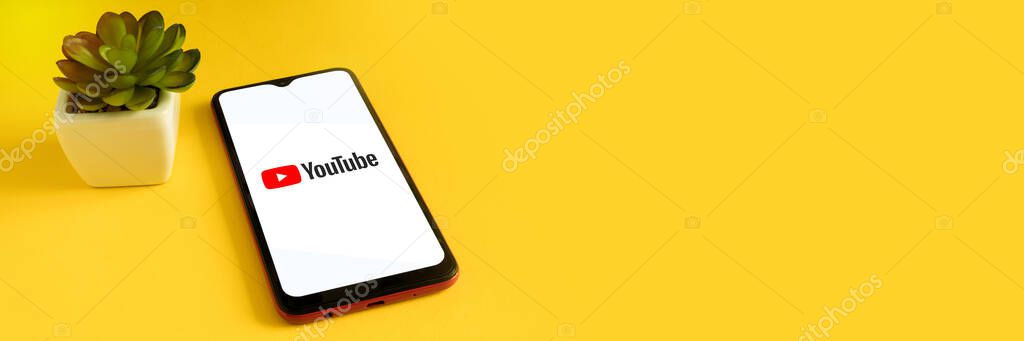 Minsk 12.05.2020. Smartphone on a yellow background with image of logo Youtube.