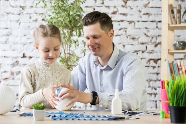 Papa en dochter maken een model van planeet Aarde. — Stockfoto