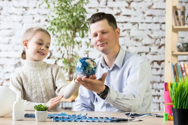 Papa en dochter maken een model van planeet Aarde. — Stockfoto