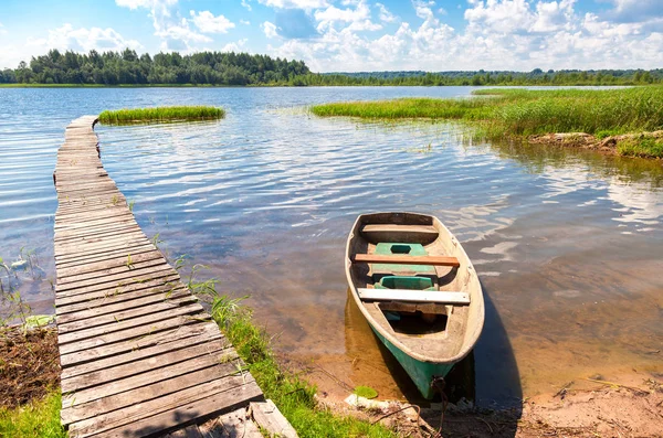 Vissersboot afgemeerd aan een pier op het meer in de ochtend in summ — Stockfoto