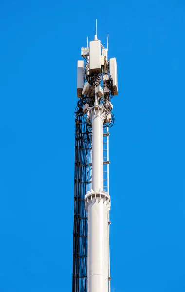Telekommunikationen står hög för mobiltelefon med antenner över en bl — Stockfoto