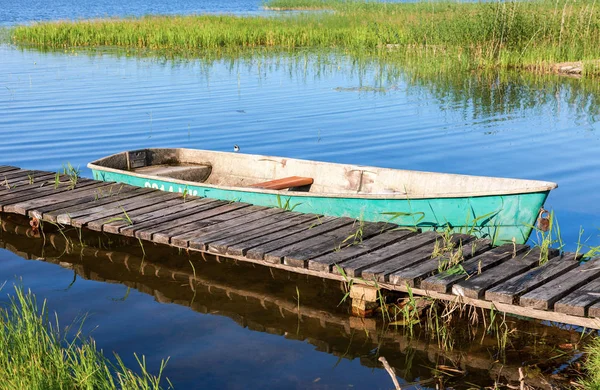 Fishing boat moored at a pier on the lake in the morning in summ — Stock Photo, Image