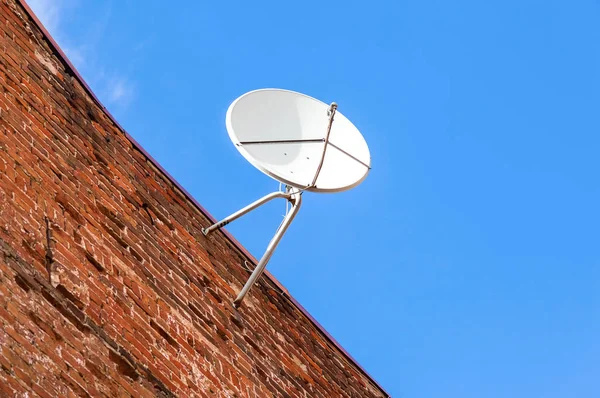 Anteny satelitarnej montowane na stary ceglany mur domu — Zdjęcie stockowe