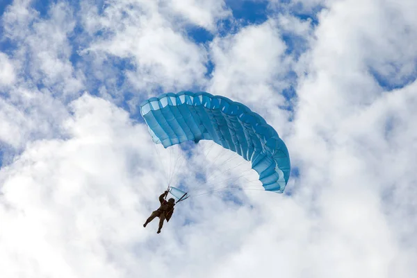 Enkele militaire parachute jumper op een blauwe vleugel parachute op blu — Stockfoto
