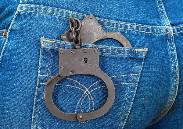 Black metal handcuffs in back jeans pocket — Stock Photo, Image