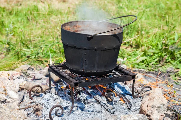 Vaření u táborového ohně venku v létě slunečný den — Stock fotografie
