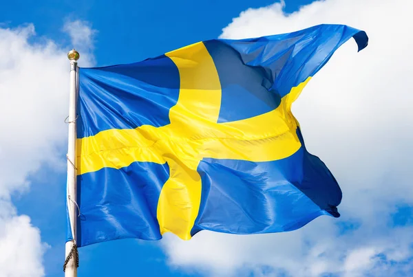 Swedish flag blue with yellow cross waving in the wind against a — Stock Photo, Image