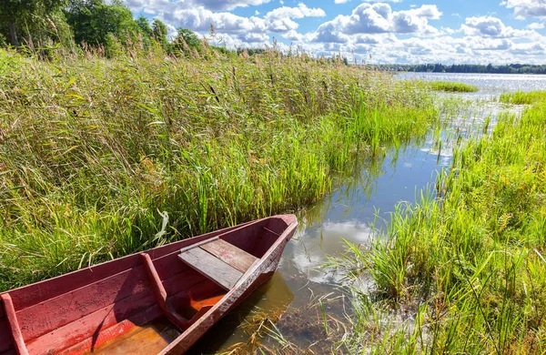 Gammal röd träbåt på sjön i sommar solig dag — Stockfoto