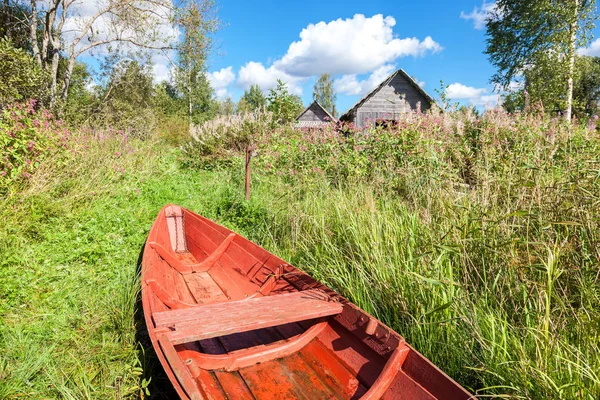 Gammal röd trä fiskebåt vid sjön i sommardag — Stockfoto