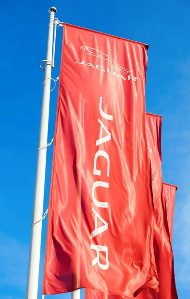 Official dealership flags of Jaguar against the blue sky backgro