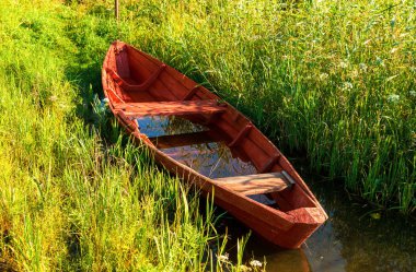 Göle yaz güneşli günde eski kırmızı ahşap balıkçı teknesi