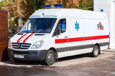 Ambulans araba sokakta park edilmiş. Metin Rusça: 