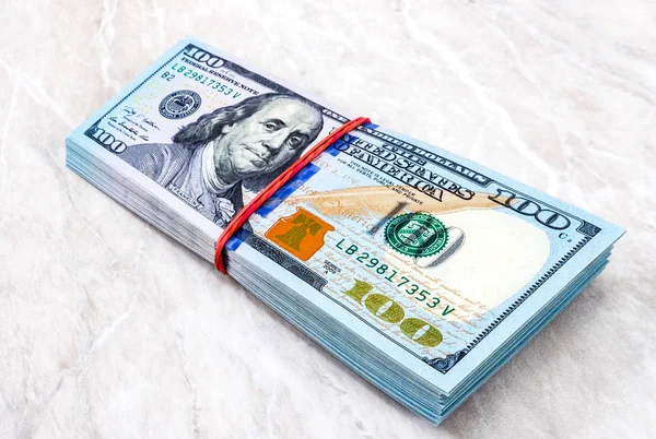 Stack of one hundred american dollar bills wrapped by rubber ban — Stock Photo, Image