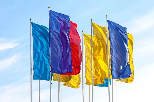 Kolorowe flagi macha na tle błękitnego nieba — Zdjęcie stockowe