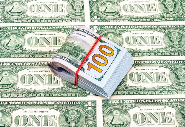 Notas de dólar dobradas envoltas por elástico sobre notas de dólares — Fotografia de Stock