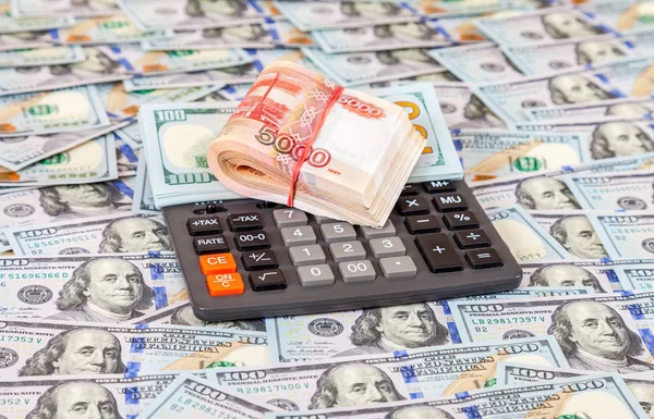 Empilement plié de roubles russes, billets en dollars et calculatrice — Photo