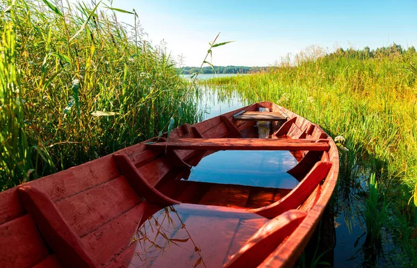 Old red wooden fishing boat at the lake in summer sunny day — Stock Photo, Image
