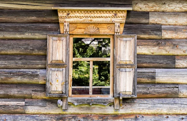 Ventana de casa de madera vieja con adorno de madera tallada — Foto de Stock