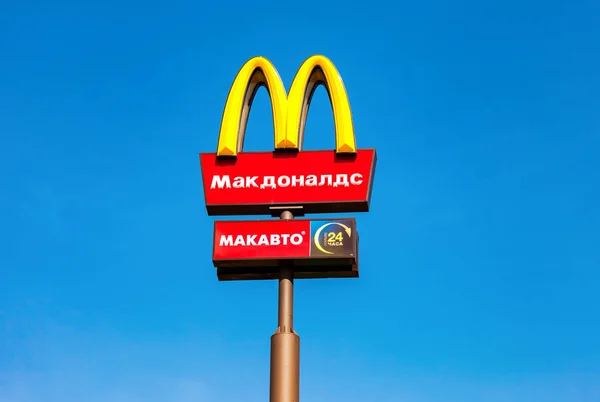 O logótipo do McDonald num poste contra o céu azul. McDonald 's é... — Fotografia de Stock