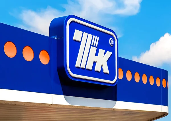 The emblem of the oil company TNK against the blue sky. — Stock Photo, Image