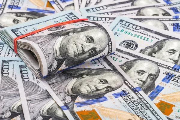 Vikta dollarsedlar insvept av gummiband över dollar sedel — Stockfoto