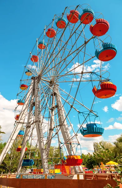 Rueda de la fortuna contra el fondo azul del cielo en el parque de la ciudad en verano — Foto de Stock