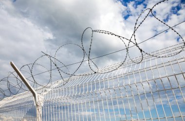 Dikenli tel mavi gökyüzü arka planı 