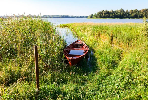 Old fishing wooden boat at the lake in summer sunny day — Stock Photo, Image