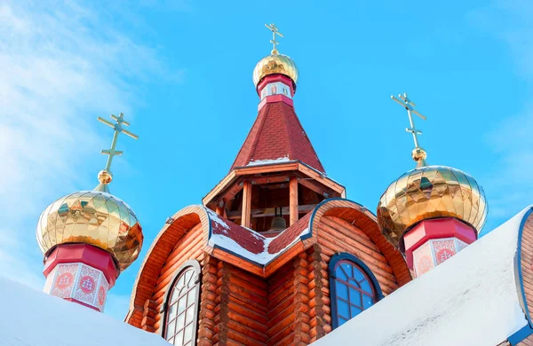 Cúpulas com cruzes em igreja ortodoxa de madeira contra o céu azul — Fotografia de Stock