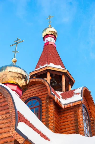 Cúpulas com cruzes em igreja ortodoxa de madeira contra o céu azul — Fotografia de Stock