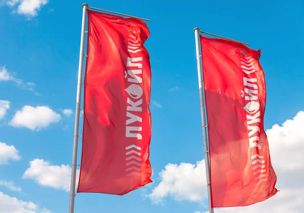 De vlaggen van de oliemaatschappij Lukoil tegen de blauwe hemel — Stockfoto