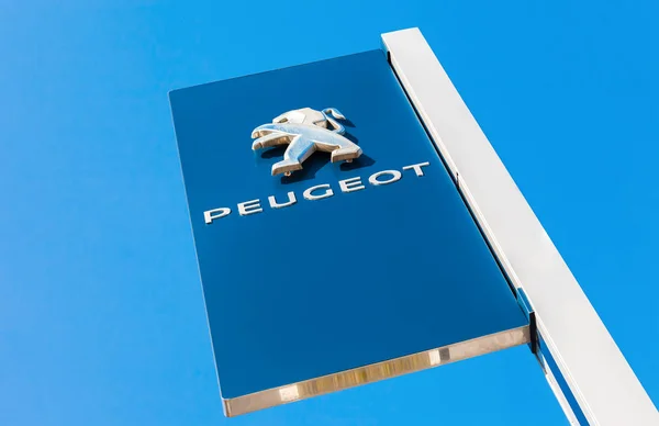 Znak oficjalnego dealera Peugeot przeciw błękitne niebo — Zdjęcie stockowe