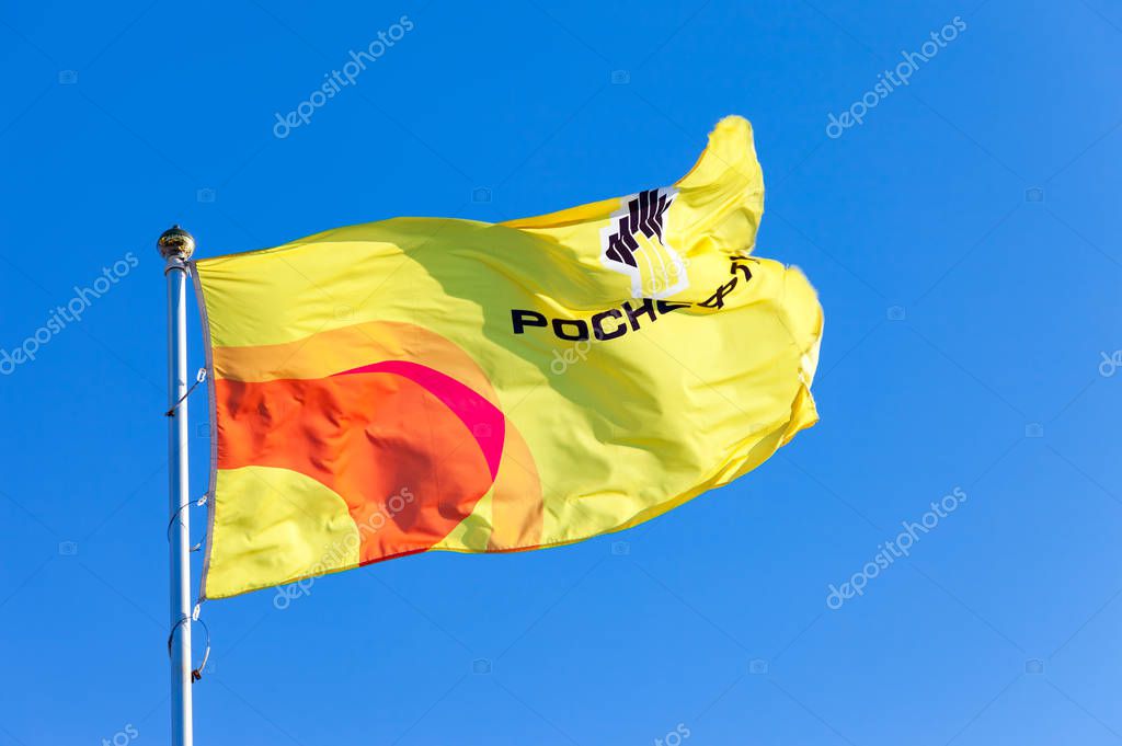 SAMARA, RUSSIA - FEBRUARY 20, 2016: The flag of oil company Rosneft against blue sky. Rosneft is one of the largest russian oil companies