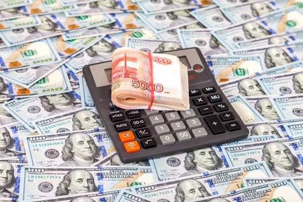 Folded stack of russian roubles and calculator on dollars backgr — Stock Photo, Image