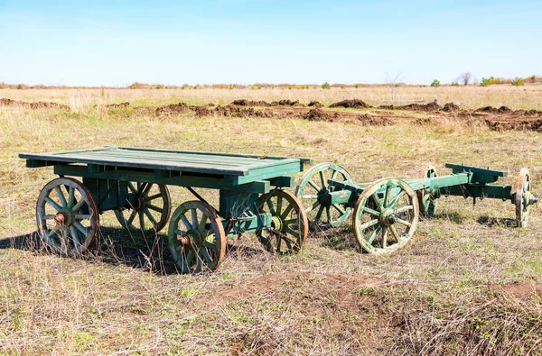 Vida en el campo. Carritos de madera viejos sin caballos se paran en el fie —  Fotos de Stock