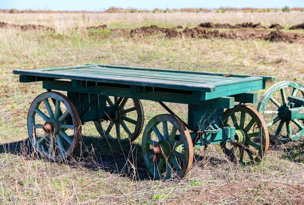 Country life. Old wooden carts without a horses stand at the fie — Stock Photo, Image