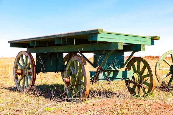 Country life. Old wooden carts without a horses stand at the fie