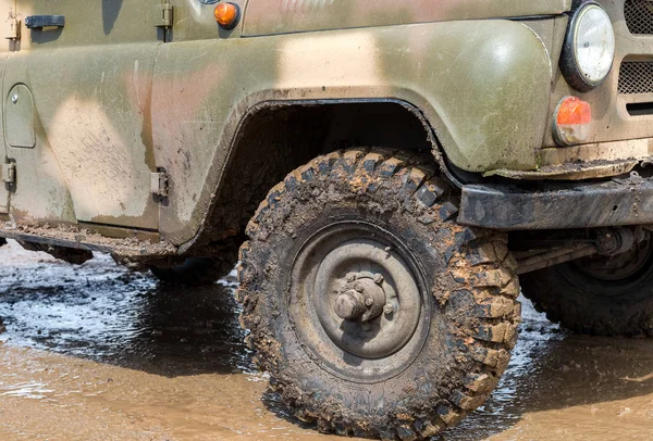 Надзвичайно брудне колесо позашляховика після їзди під дощем на брудному русі — стокове фото