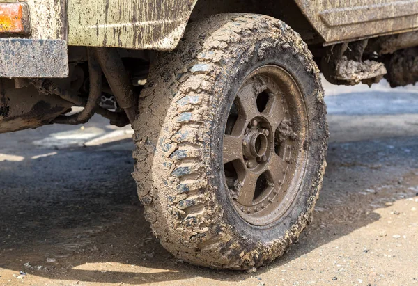 Extremely dirty SUV wheel after driving in the rain on dirty rur — Stock Photo, Image