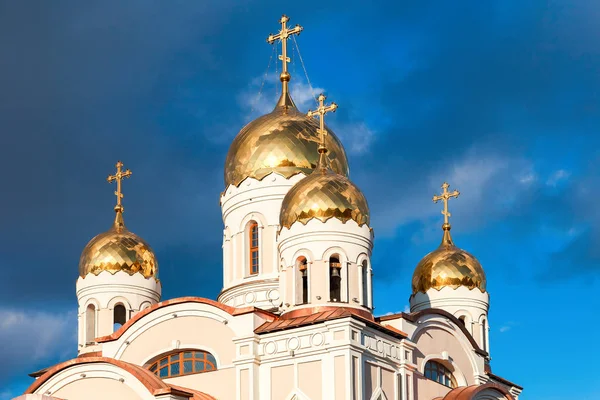 Iglesia ortodoxa blanca con cúpulas doradas contra el azul oscuro sk —  Fotos de Stock