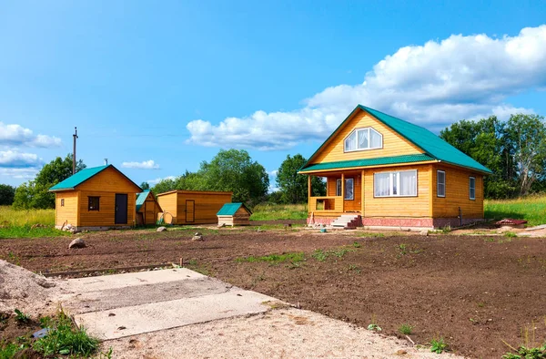 Neues Landhaus aus Holz mit Nebengebäuden im Sommer — Stockfoto
